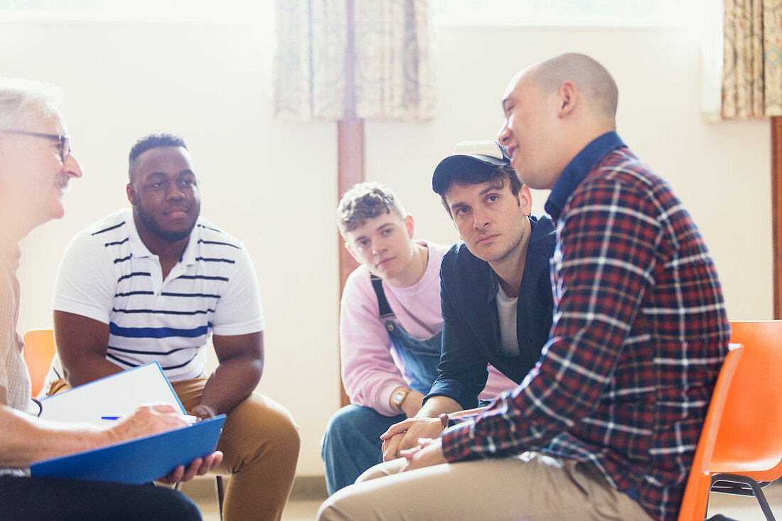 Attentive men talking in group therapy