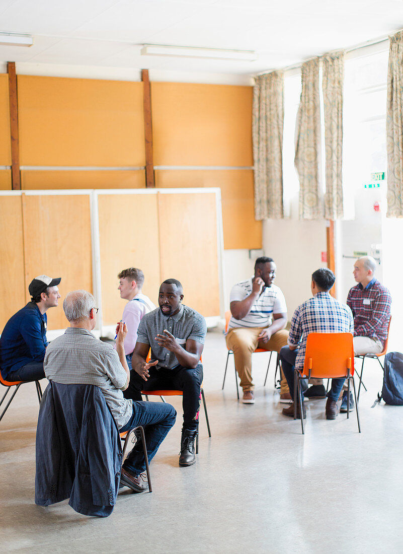 Men talking in group therapy in community centre