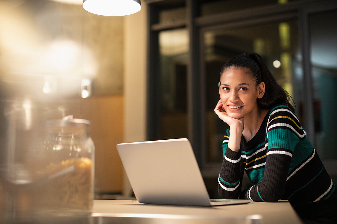 Portrait woman using laptop at home at night