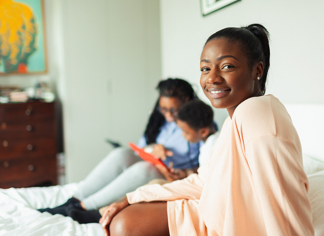 Portrait young woman relaxing on bed with mother and son