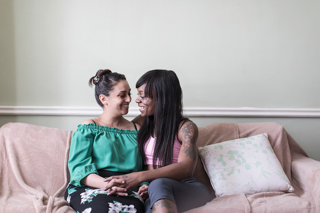 Affectionate lesbian couple on sofa
