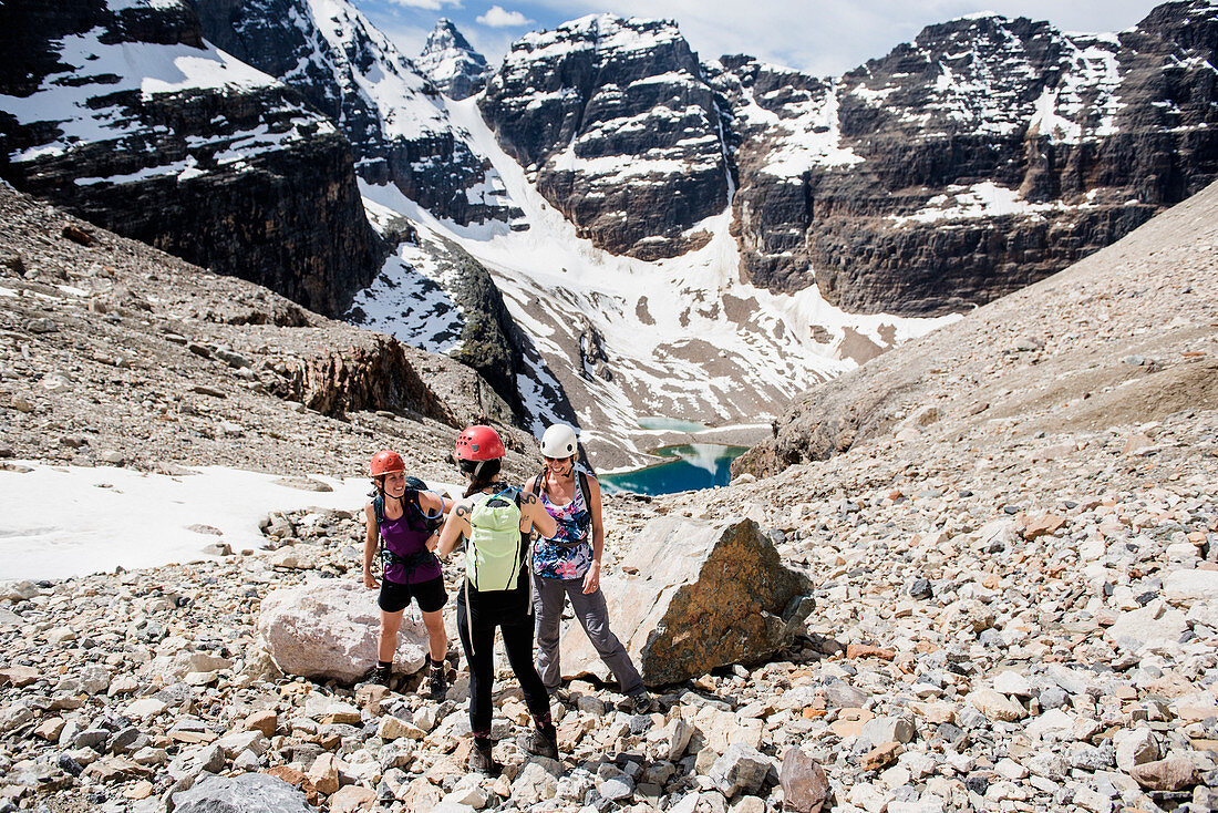 Women hiking in sunny, craggy mountain landscape, Canada
