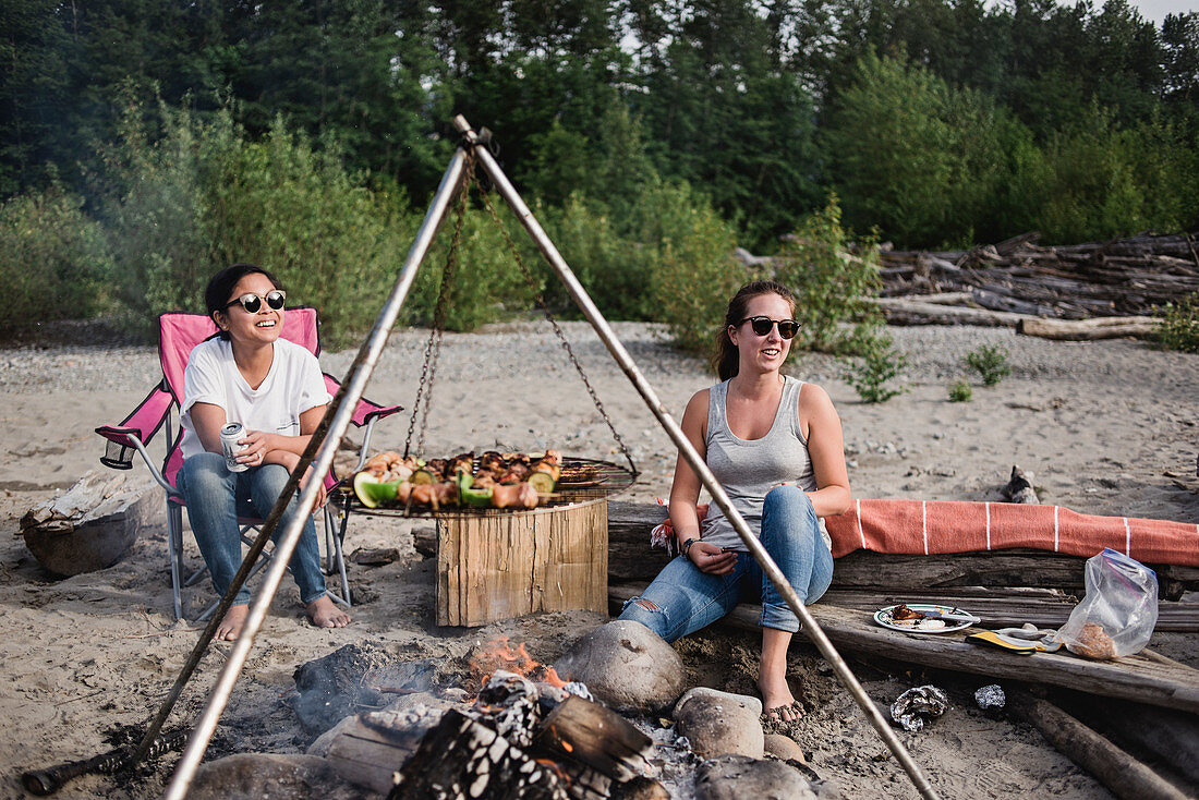 Women relaxing, enjoying beach barbecue