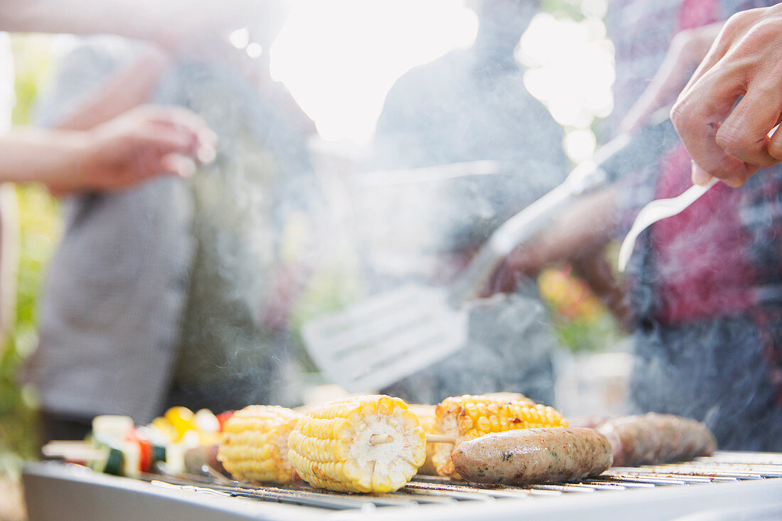 Corncobs, sausages and vegetable on barbecue grill
