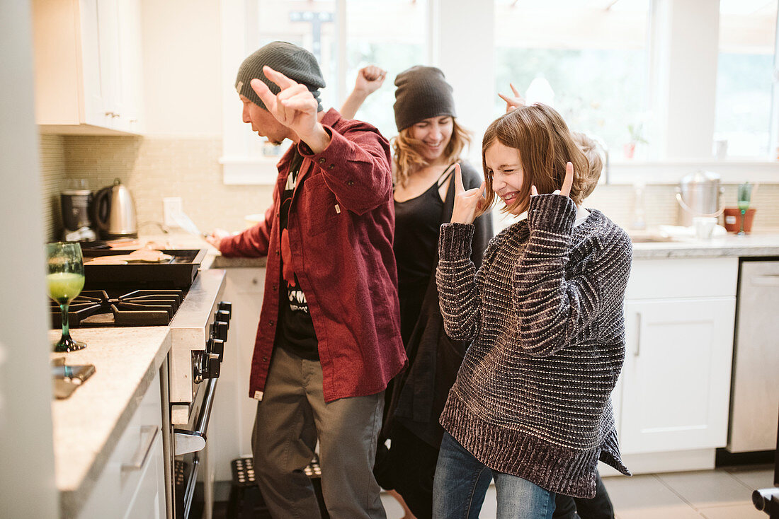 Carefree family dancing and cooking