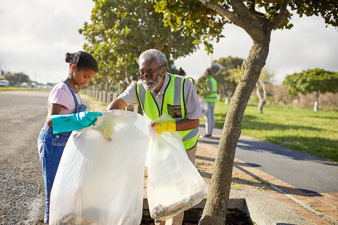Grandfather and granddaughter volunteers cleaning up litter