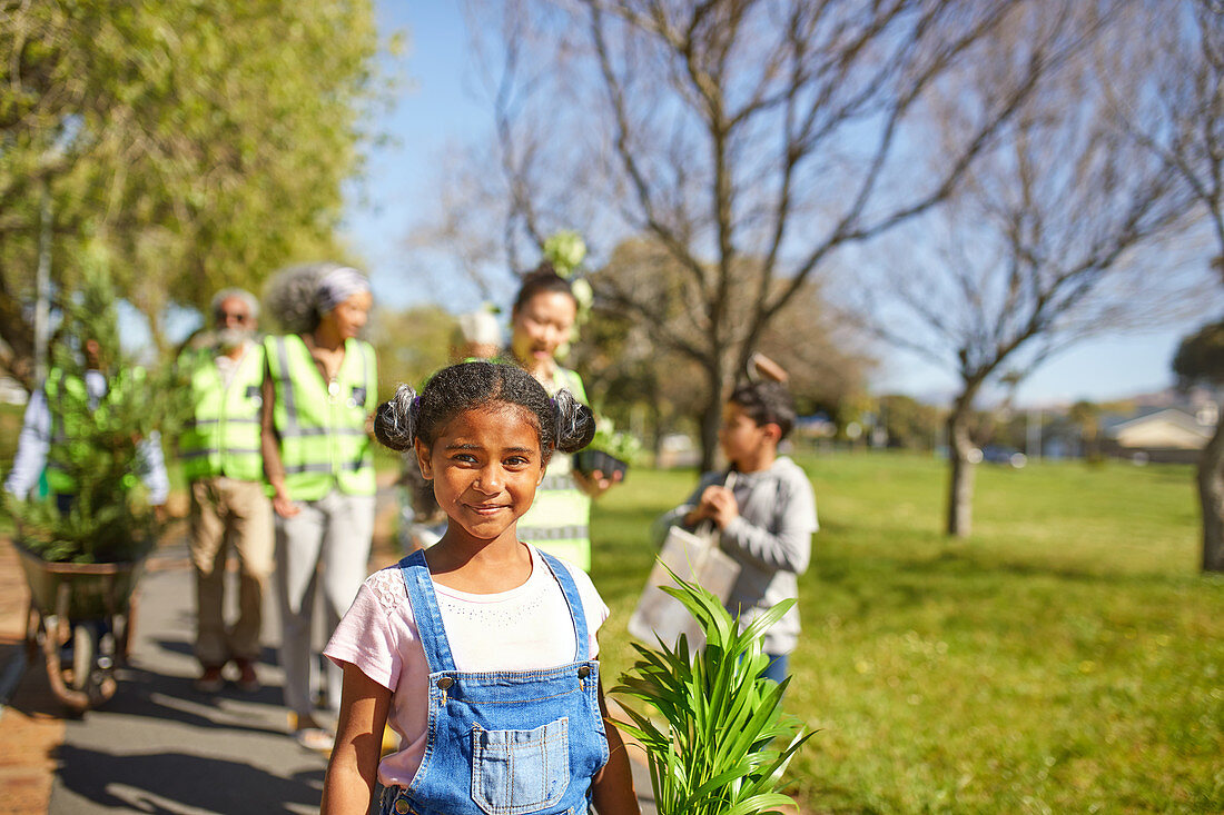 Portrait girl volunteering, planting trees in park