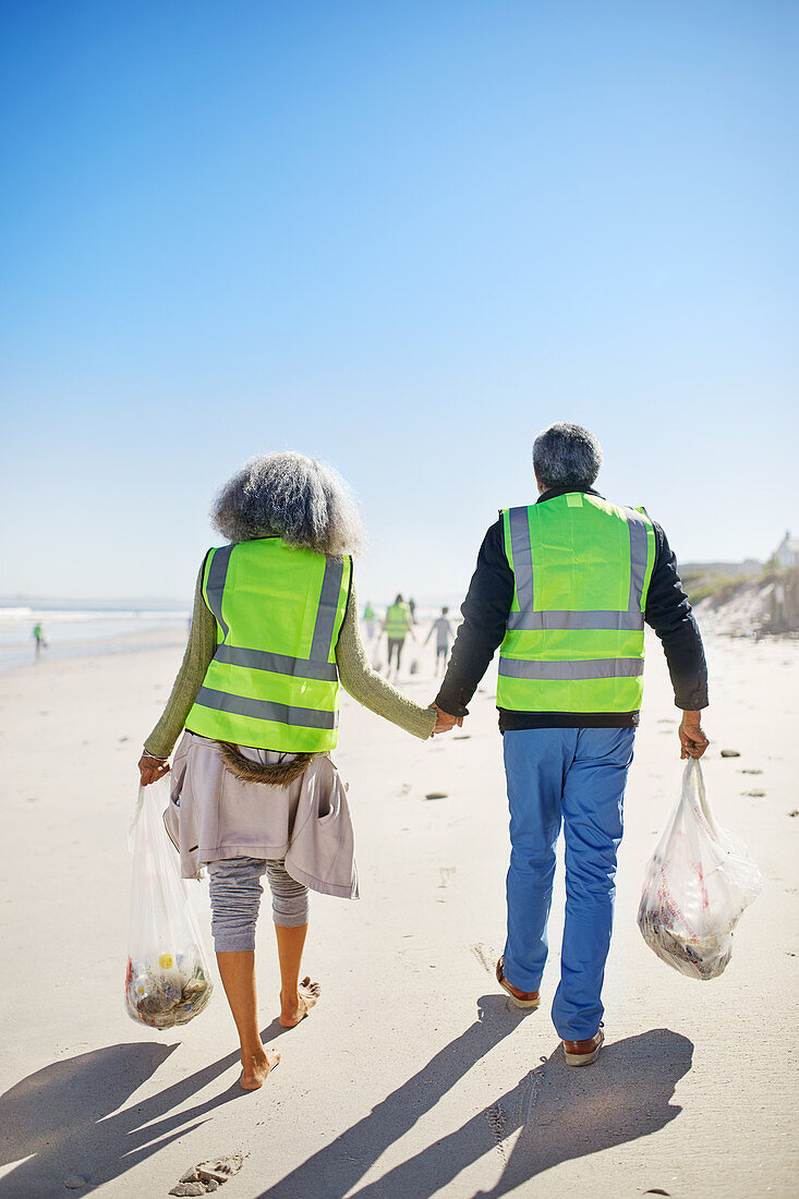 Affectionate senior couple volunteers cleaning up litter