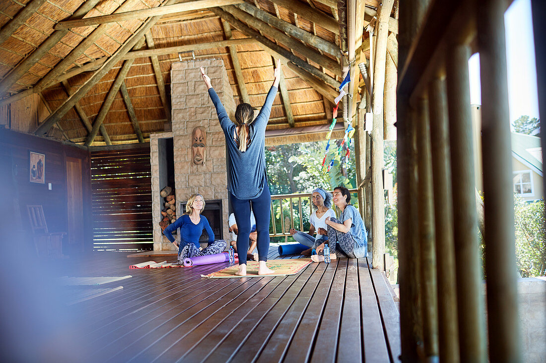 Woman leading yoga retreat in hut
