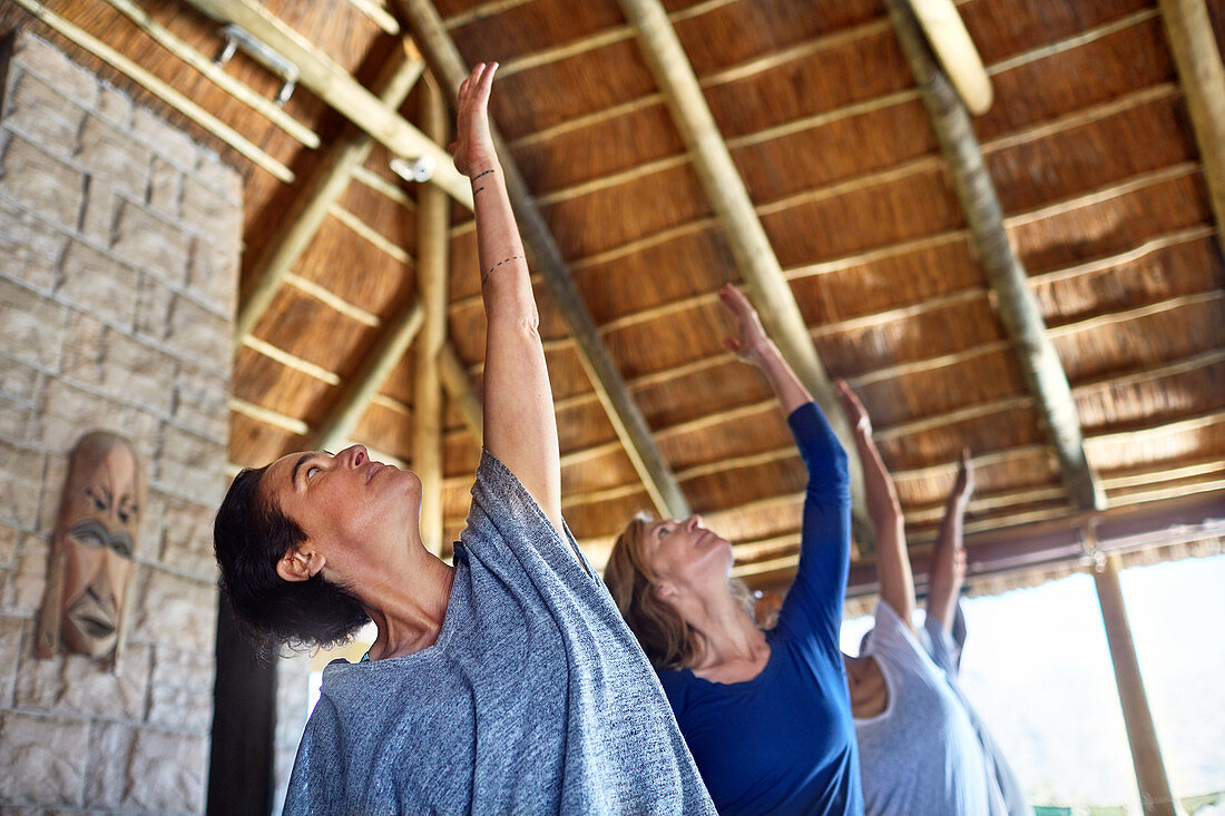 Women practicing yoga during retreat in hut
