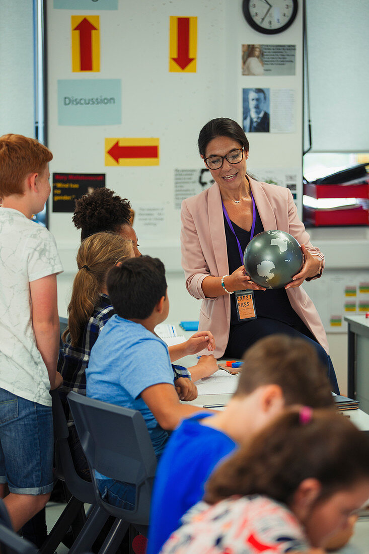 Female geography teacher with globe teaching lesson