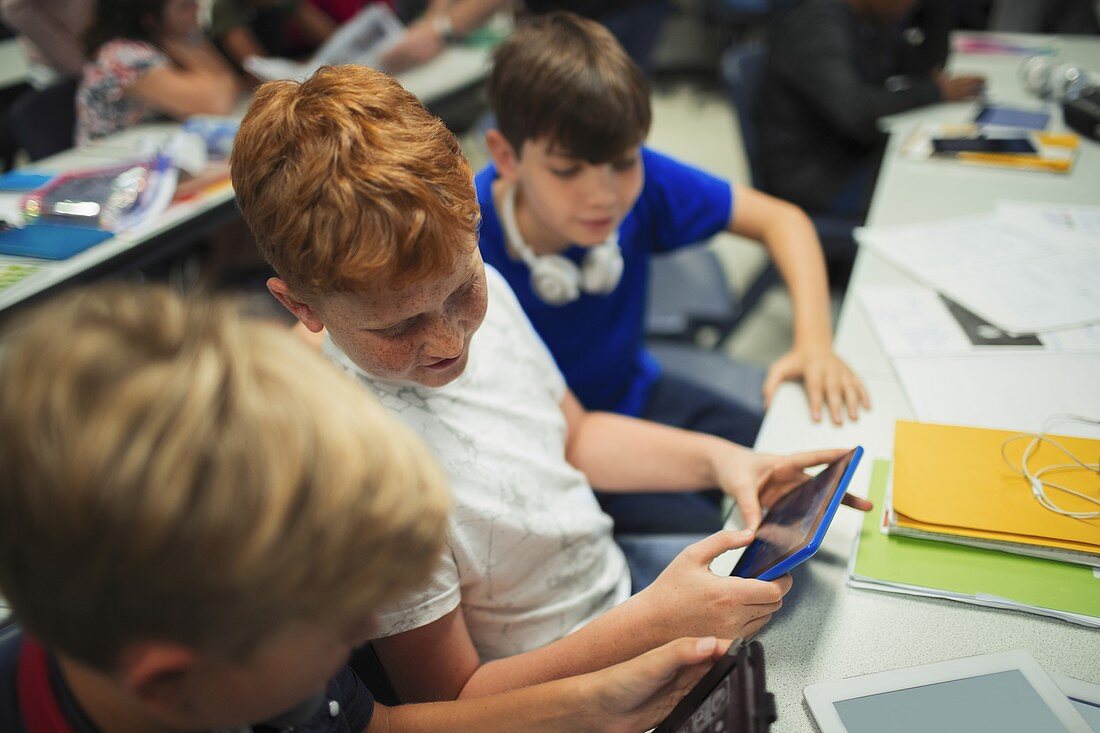 school boy students using tablets at desk