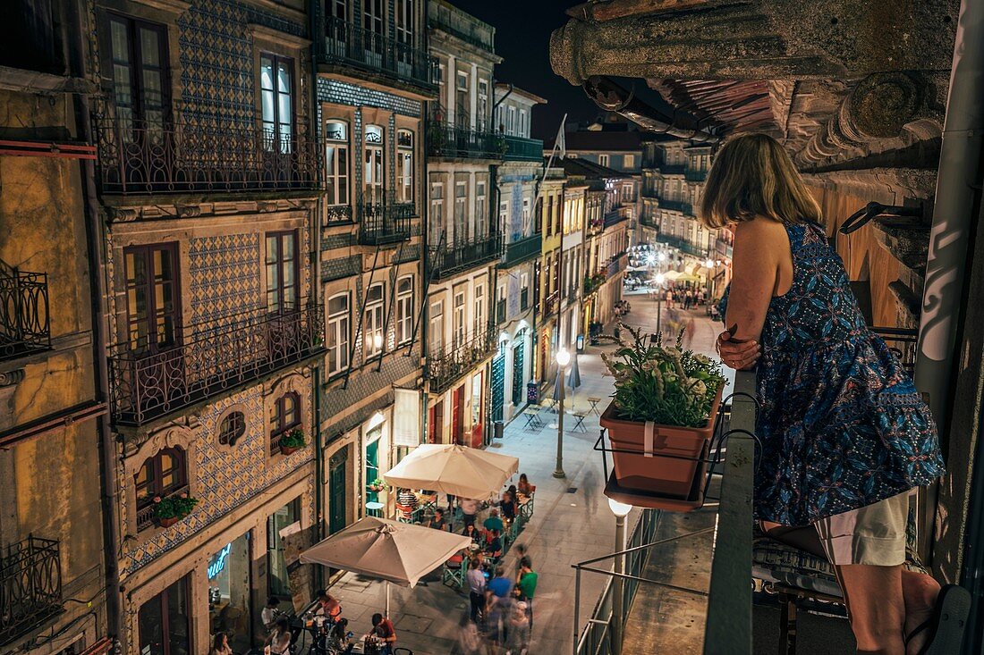 Woman standing on balcony, Porto, Portugal