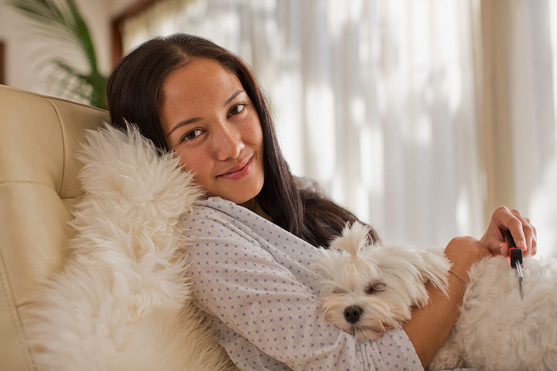 Portrait smiling young woman cuddling with dog
