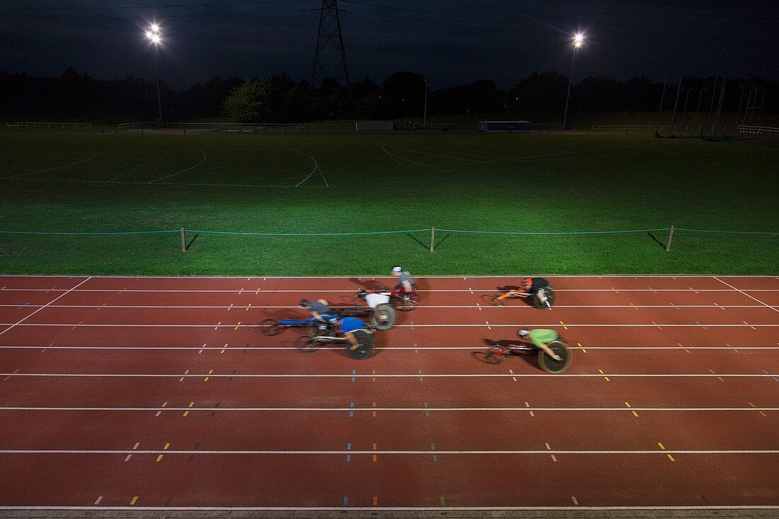 Paraplegic athletes in wheelchair race at night