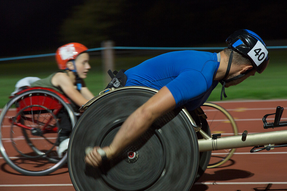 Paraplegic athletes in wheelchair race at night