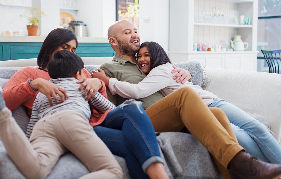 Happy, affectionate family on living room sofa
