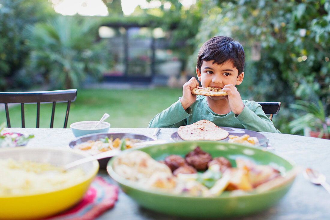 Boy eating naan bread at dinner table