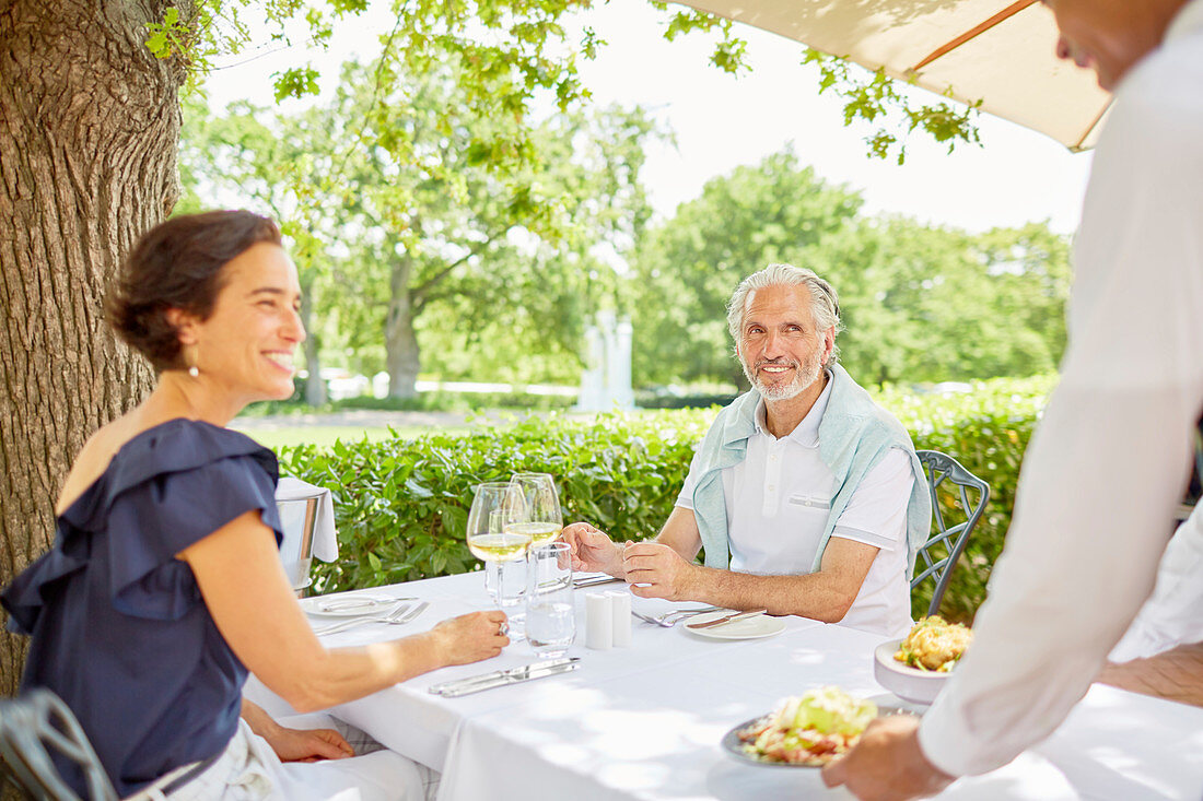 Waiter serving food to mature couple