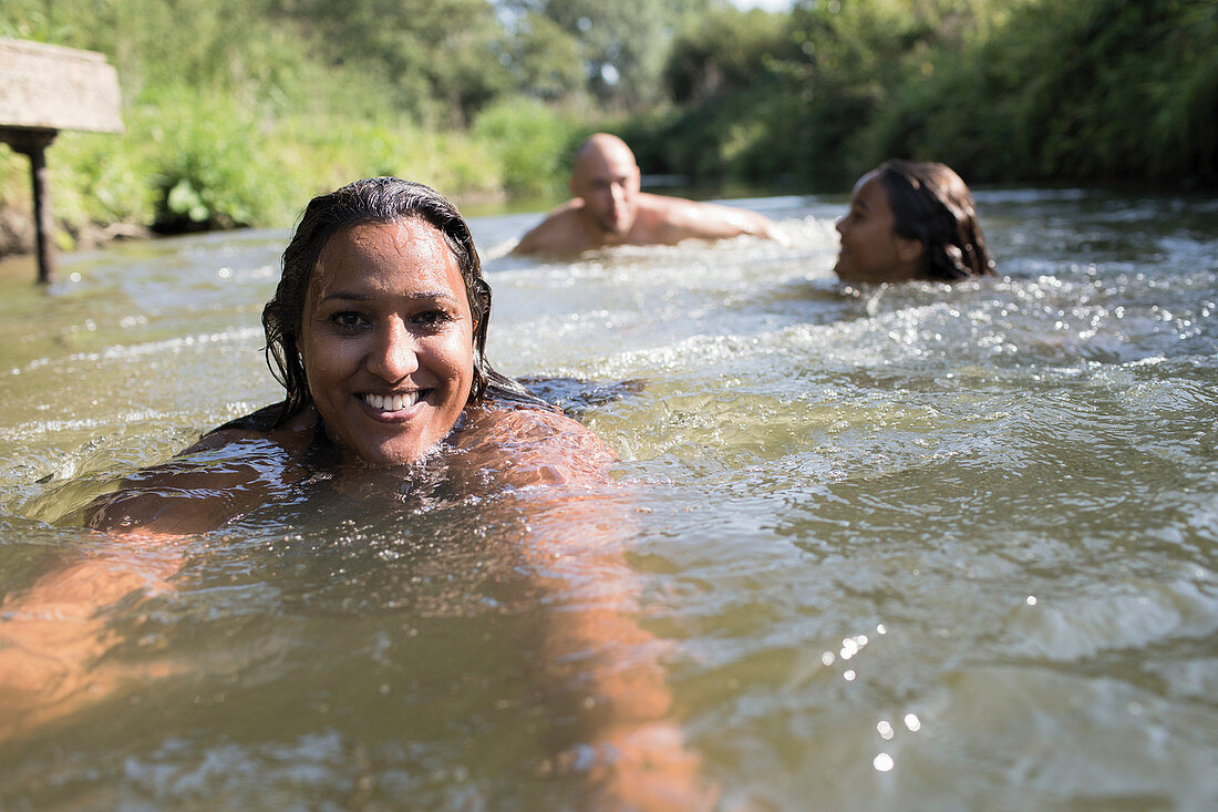 Portrait woman swimming with family in river