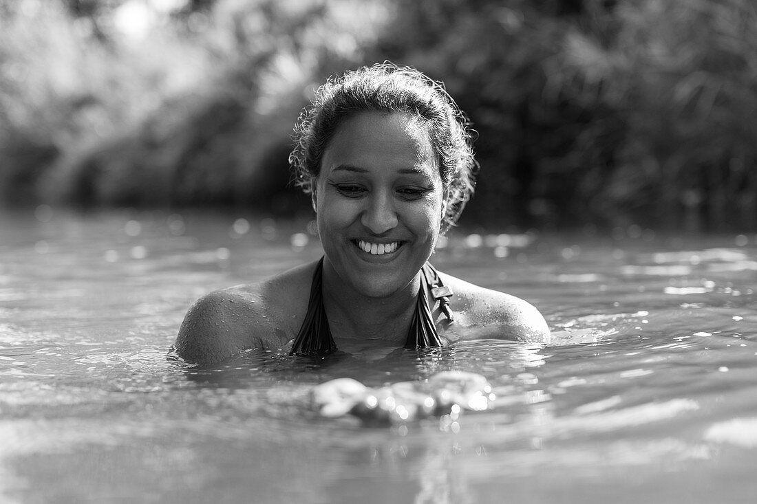 Happy woman swimming in river
