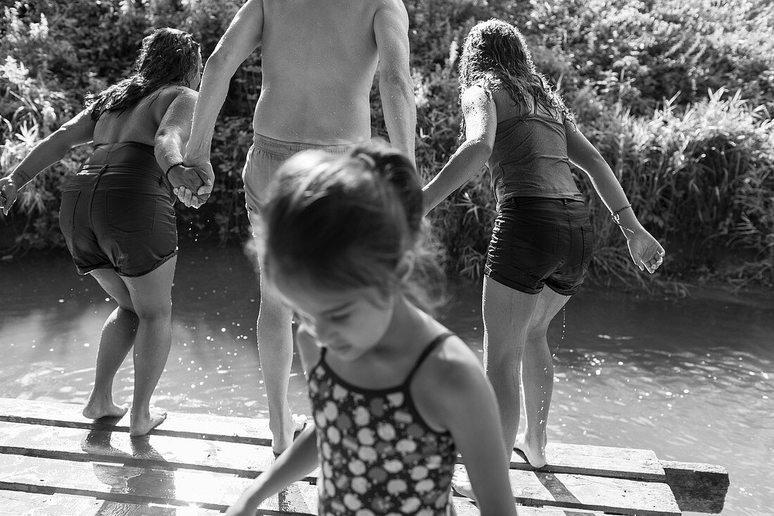Family playing, jumping into river
