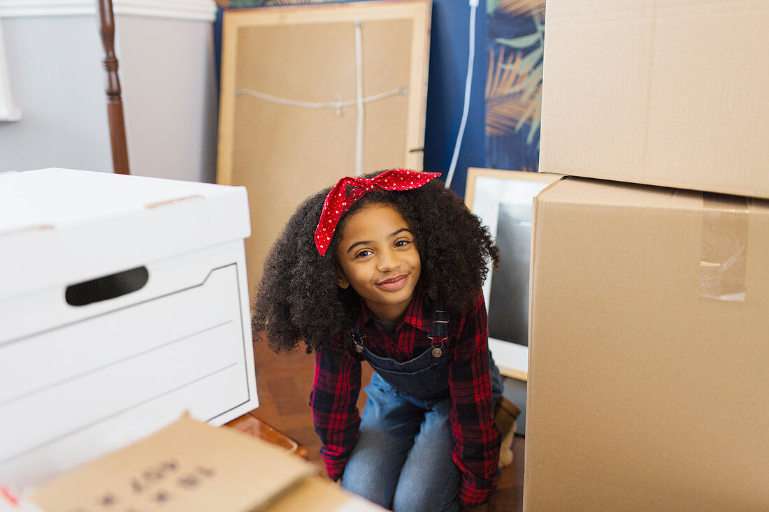 Portrait happy, cute girl among moving boxes