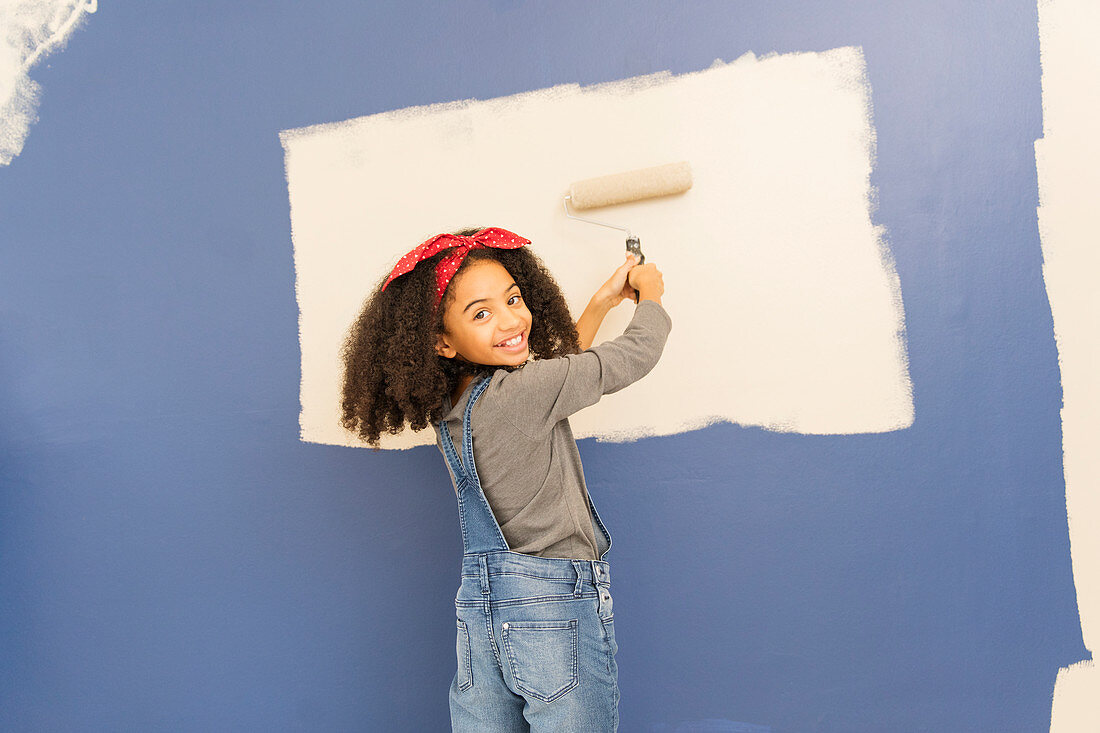 Portrait happy, confident girl painting wall