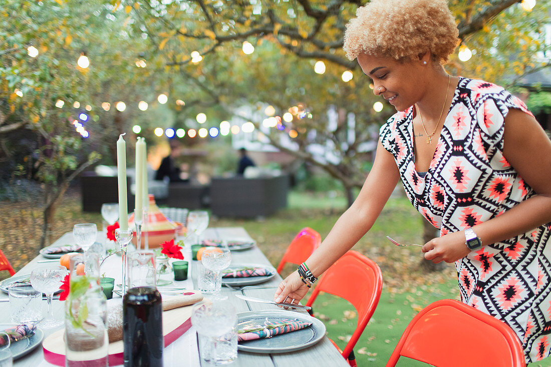Woman setting table for dinner garden party