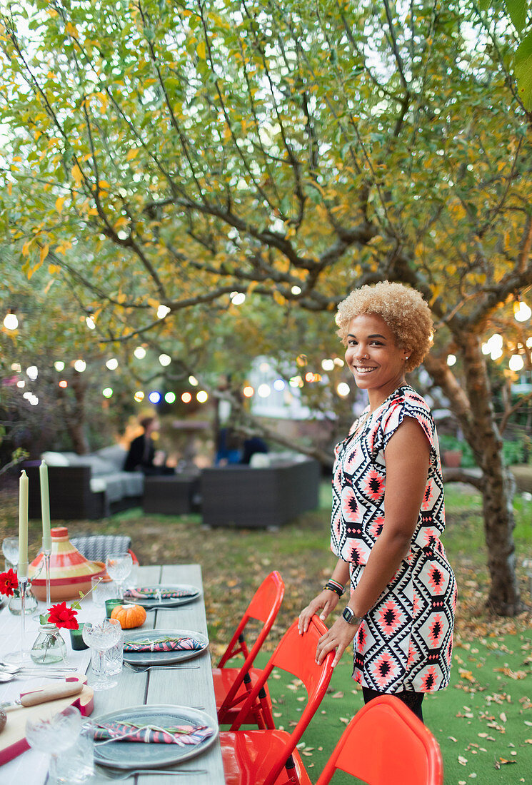 Portrait happy woman hosting dinner garden party