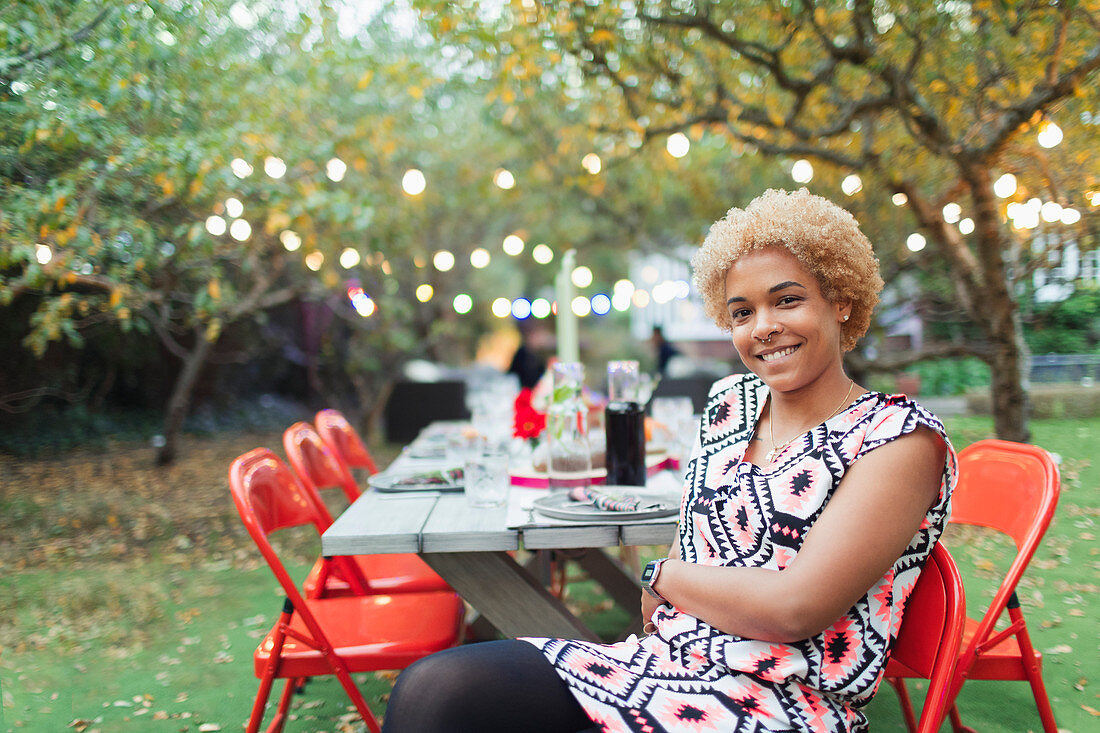 Portrait happy woman hosting dinner garden party