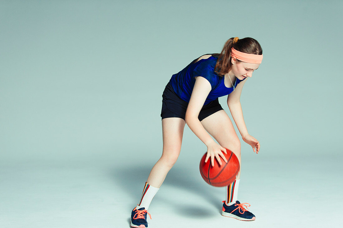 Teenage girl basketball player dribbling ball
