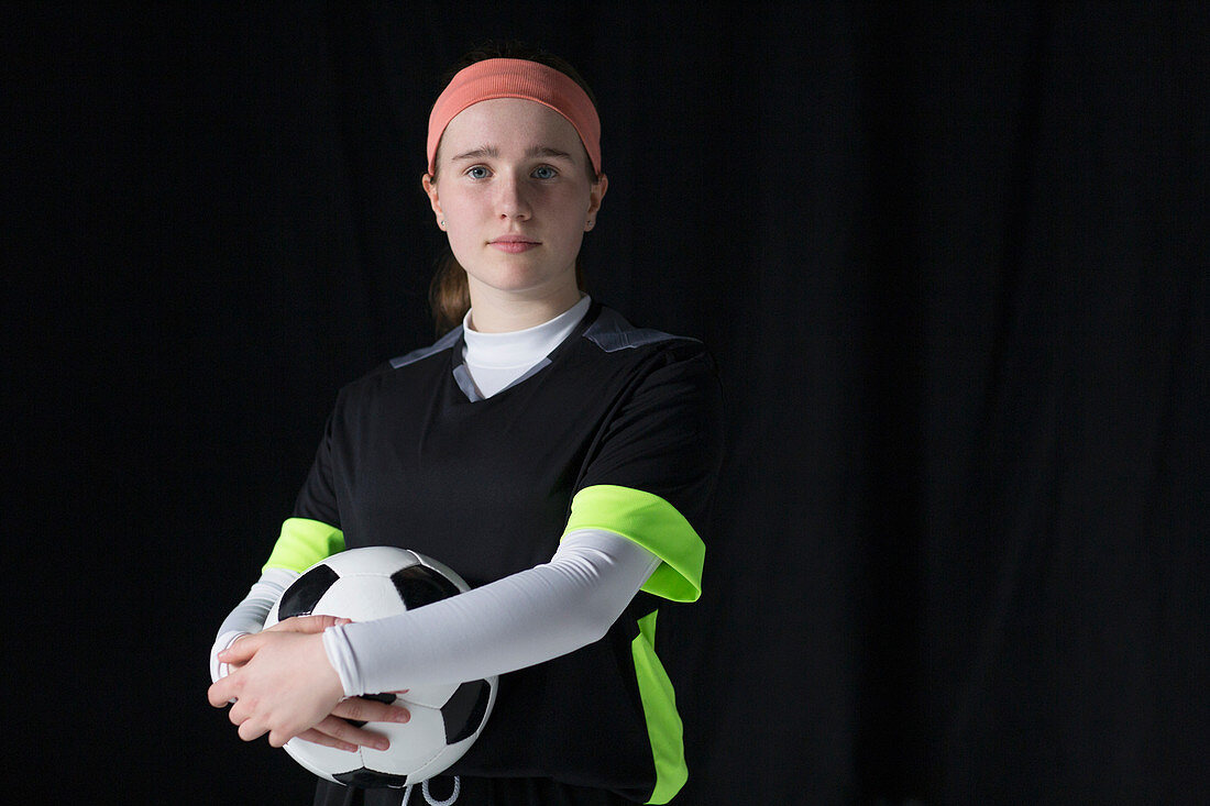 Teenage girl soccer player holding soccer ball