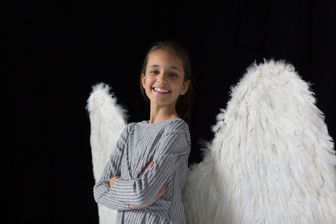 Portrait smiling, confident girl wearing angel wings