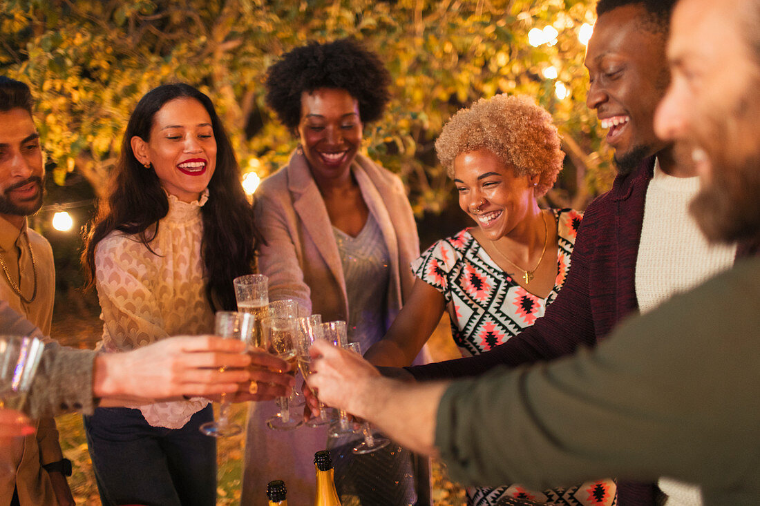 Happy friends celebrating, toasting champagne