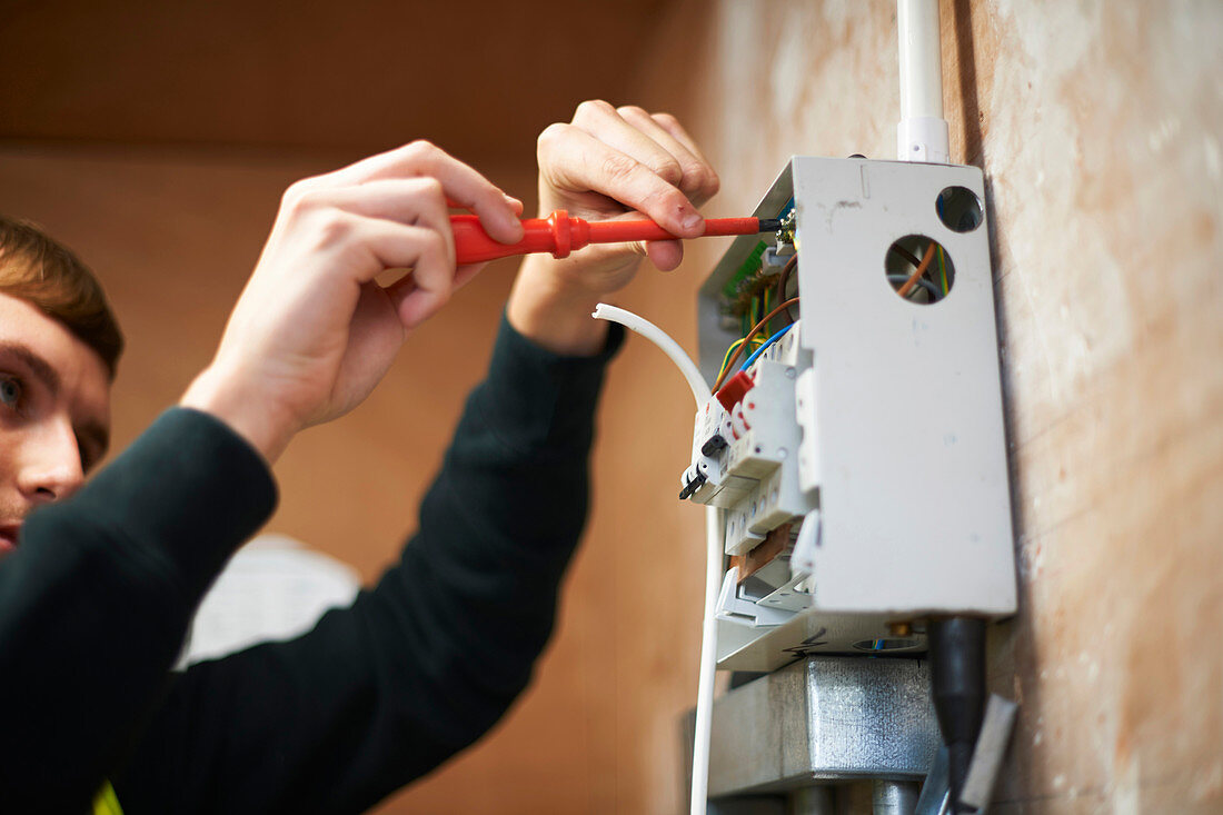 Male electrician working at electric panel