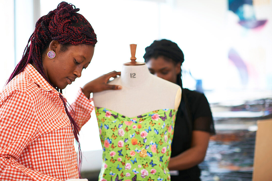 Female fashion designers using dressmakers model