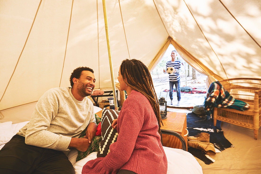 Happy couple relaxing in campsite yurt