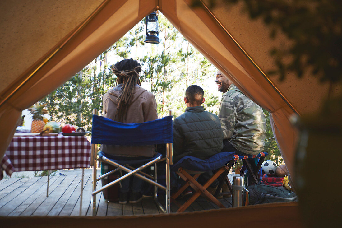 Family relaxing outside camping yurt