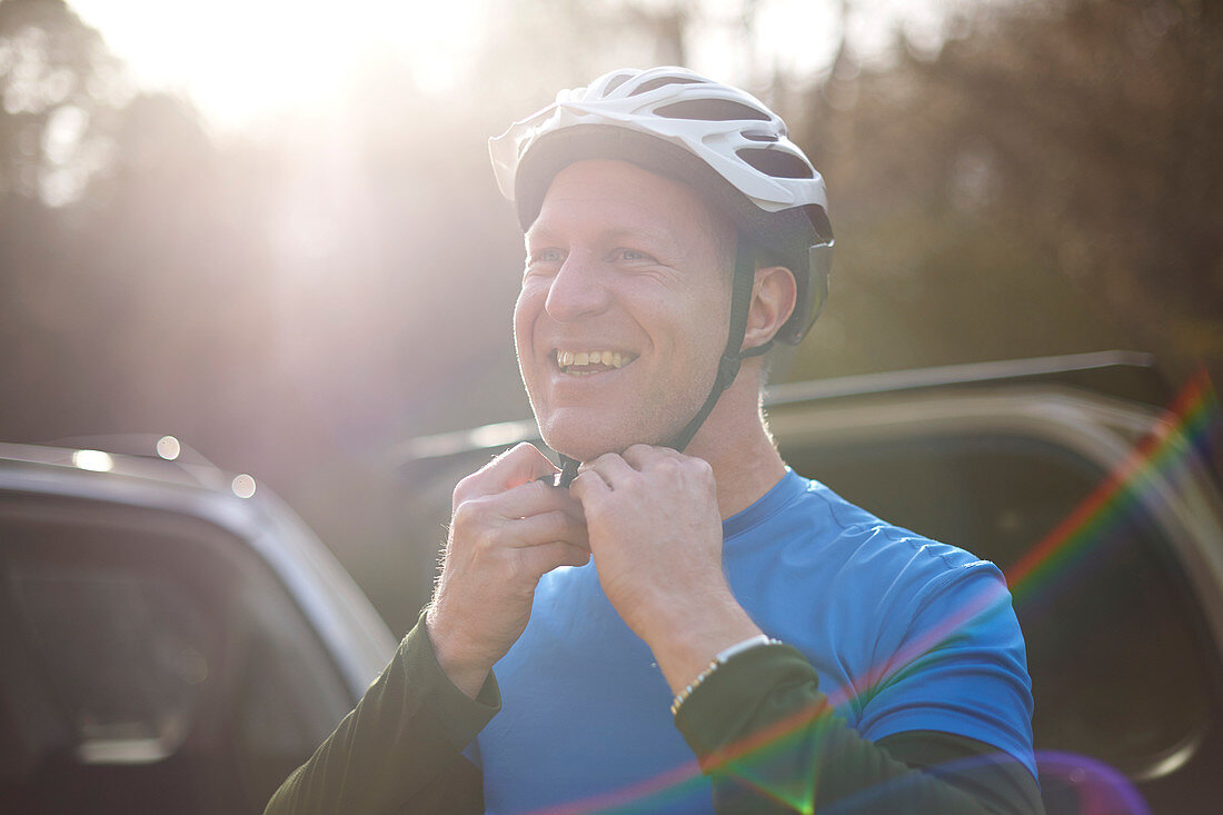 Portrait smiling man fastening bike helmet