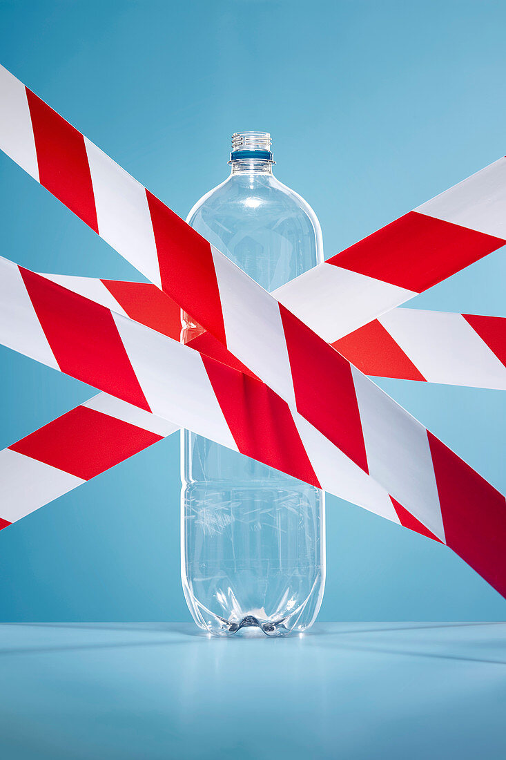 Red and white tape covering plastic water bottle