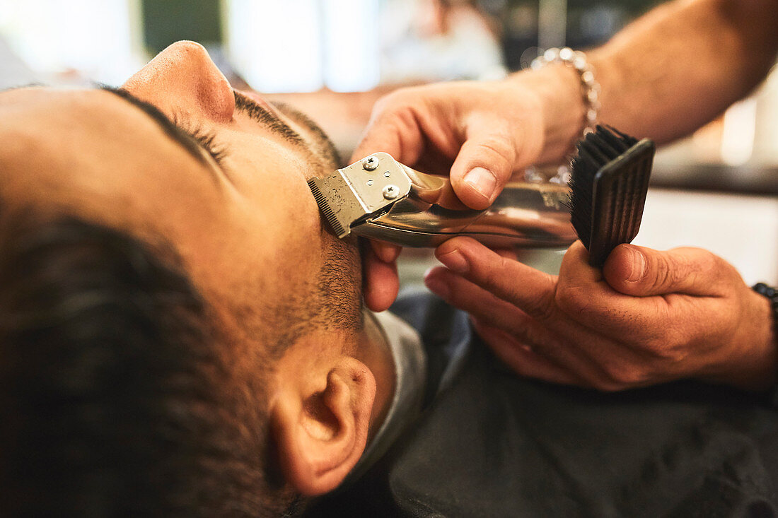Close up man receiving a shave in barbershop