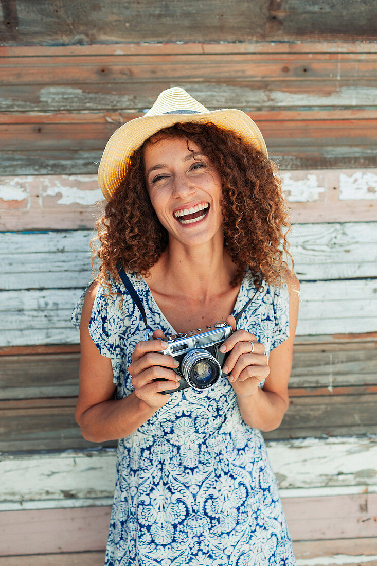 Happy, carefree young woman with retro camera