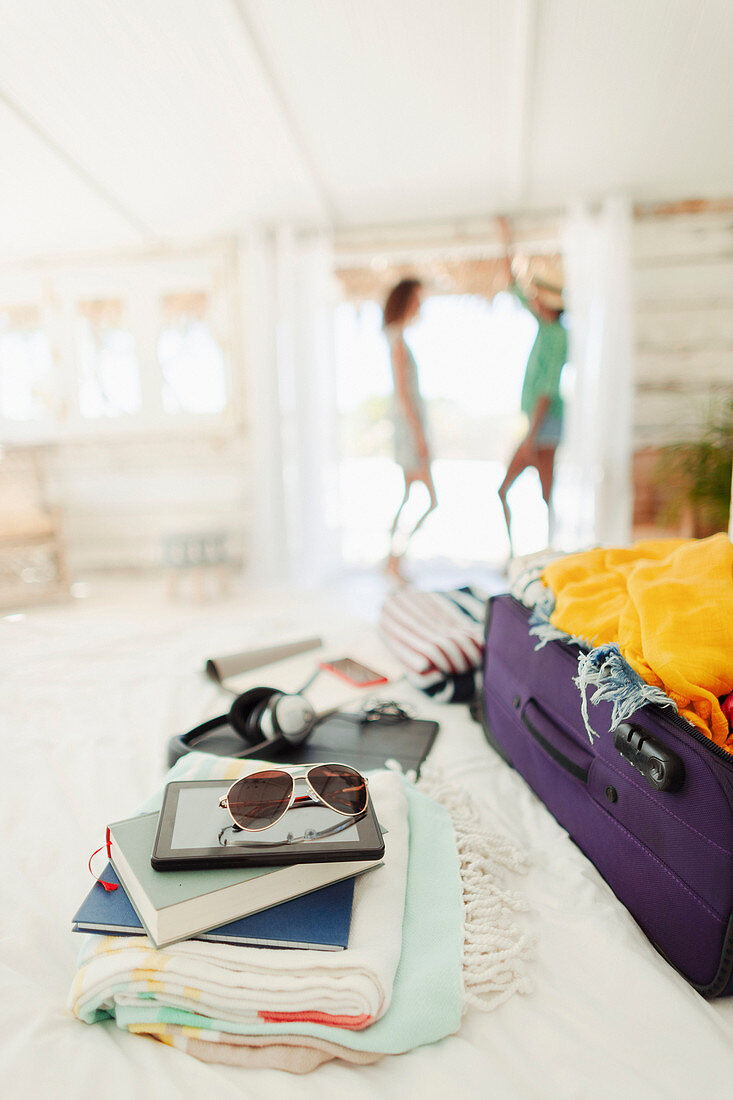 Suitcase, books, beach towels and sunglasses