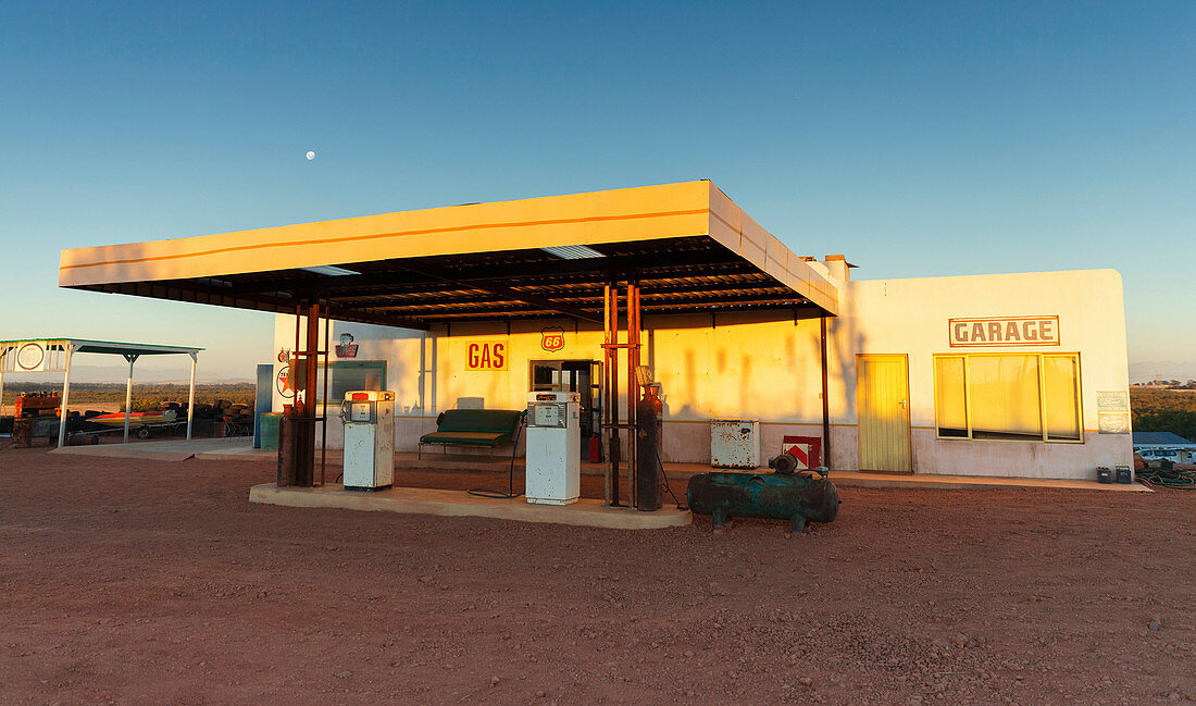 Abandoned gas station and garage at sunset