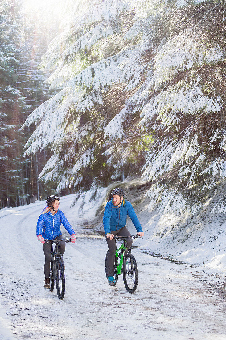 Couple mountain biking in snow