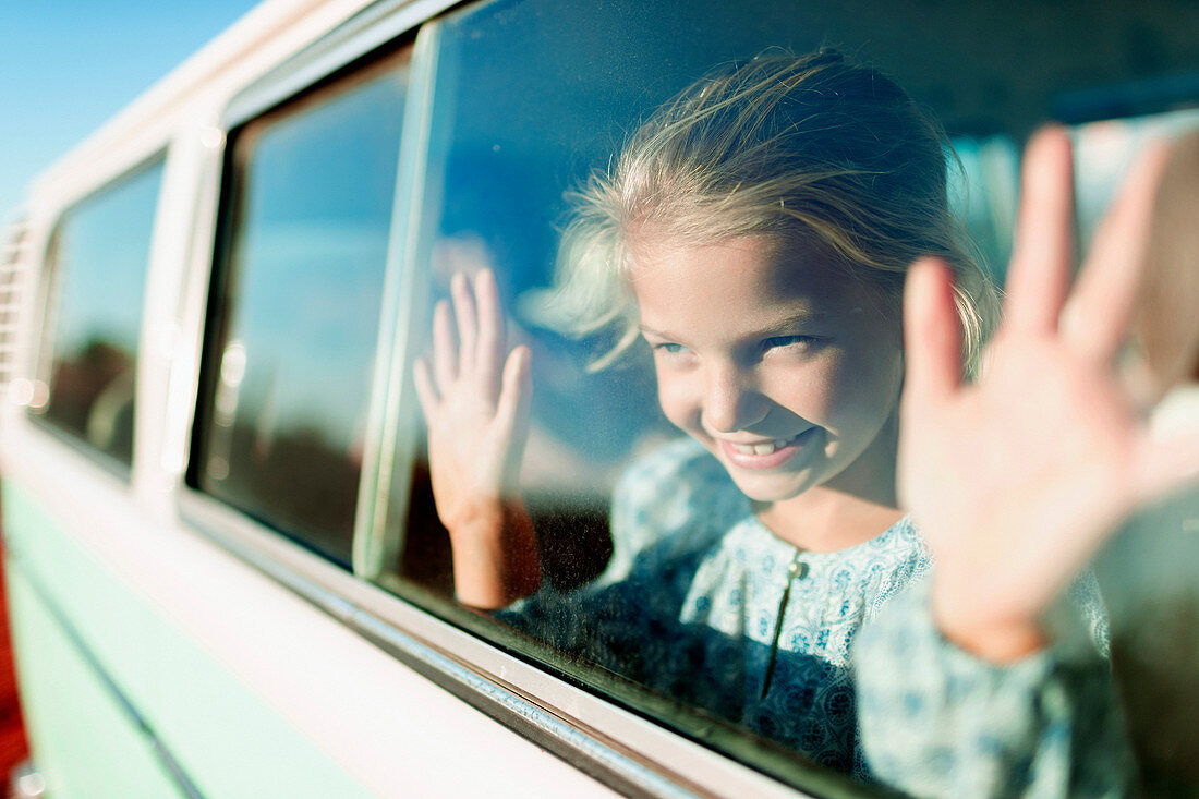 Happy, carefree girl riding in van
