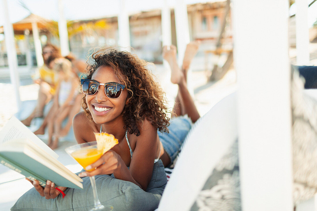 Young woman reading book on beach