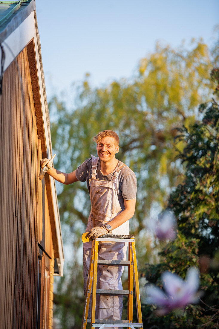 Portrait male painter on ladder painting