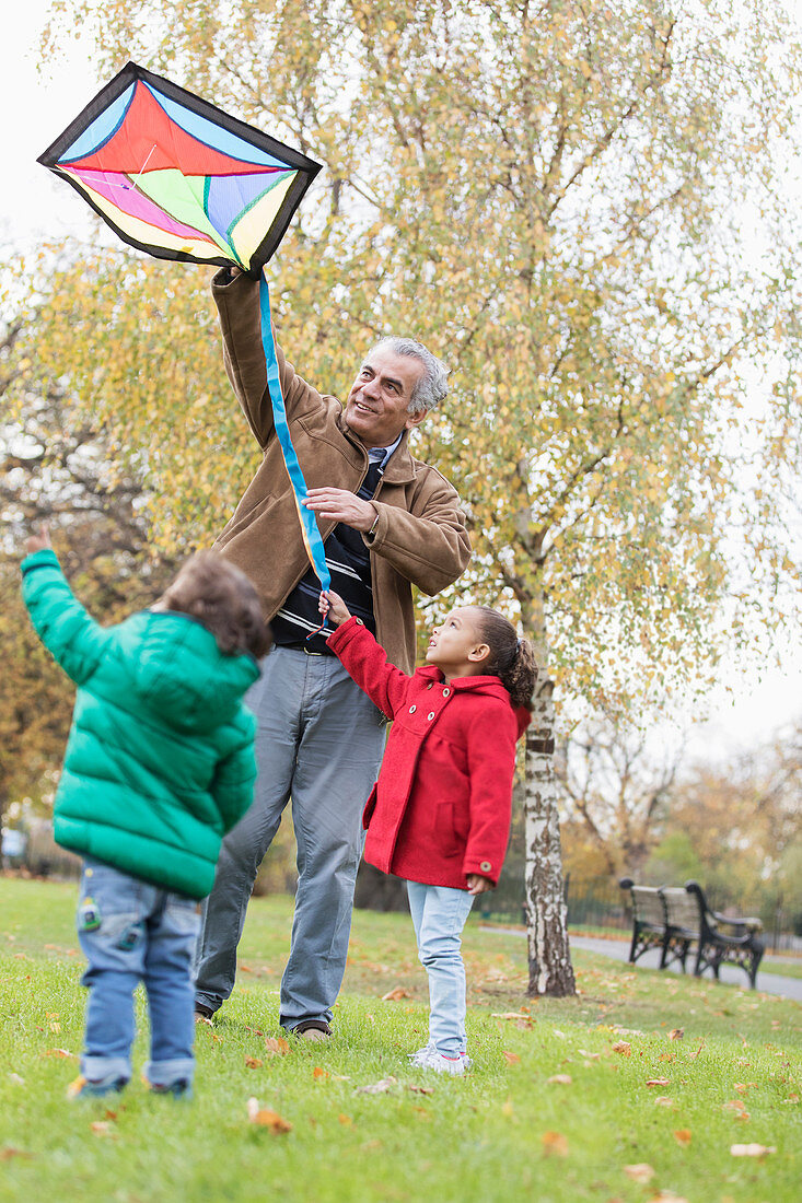 Grandfather and grandchildren flying a kite